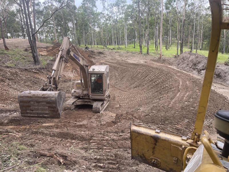 Komatsu excavator and dozer cutting a building pad on a bush block
